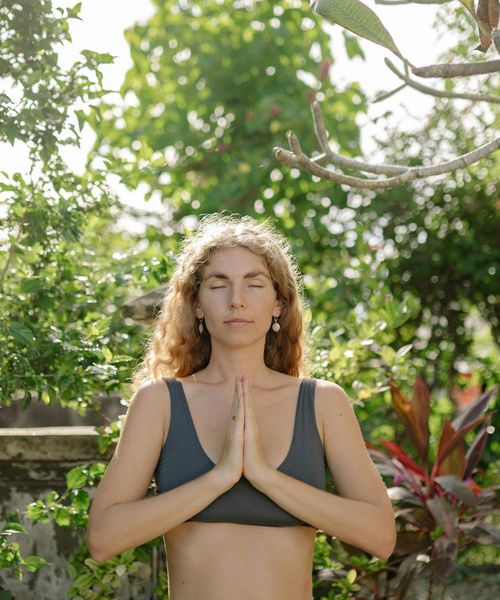 Woman meditating peacefully in a beautiful natural setting.